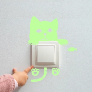 Glow-in-the-dark cat wall stickers in green fluorescence applied around a white room switch