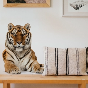 Detailed view of woven linen lumbar pillow with black stripes on a wooden bench