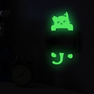 Detail showing luminous cat sticker glowing green around a light switch in the dark