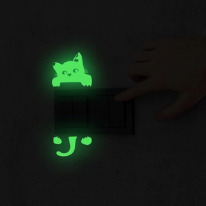 Glow in the dark cartoon cat wall sticker showing bright green light on a switch