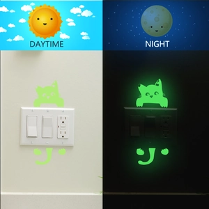 Luminous cat switch sticker showing glow-in-the-dark effect in day and night contrast