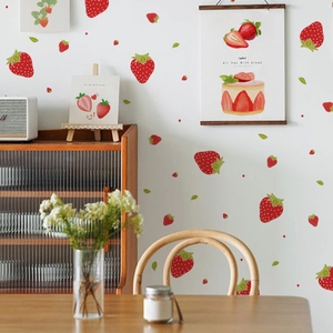 Detail of strawberry wall decals with green leaves applied in a cozy home interior