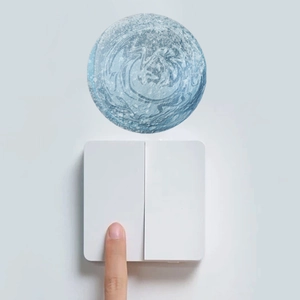 Primo piano di una mano che preme un interruttore con adesivo da parete luna blu luminosa
