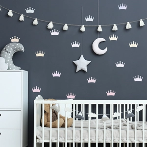 Luminous crown wall stickers in pink and white set in a cozy nursery room scene
