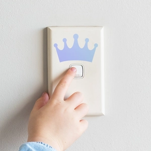 Close-up of a gradient crown wall sticker applied on a white light switch panel