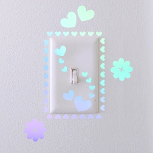 Close-up of heart and flower decals on a light switch with macaron gradient colors