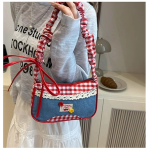 Close-up of red plaid and denim bag with lace trim, cherry patches and yellow flower