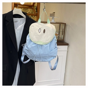 Dettaglio dello zaino in nylon azzurro con motivo a pera e patta color crema