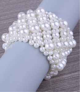 Macro detail of wide multi-layer pearl stretch bracelet with elegant white beads