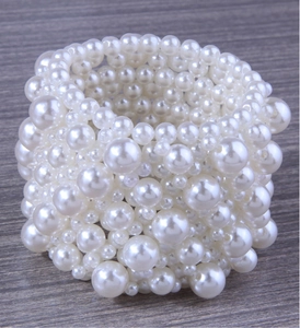 Close-up of handmade multi-layer wide stretch bracelet with assorted white pearls