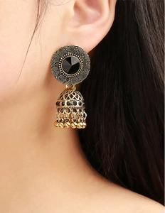 Nahaufnahme indischer Jhumka-Ohrringe mit schwarzen Kristallen und goldenen Quasten