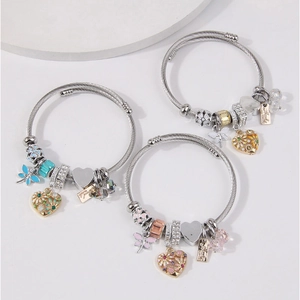 Detailed view of beaded charm bracelets with dragonfly, heart, and floral pendants