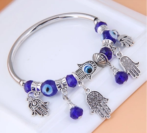 Dettaglio del bracciale in argento con perline malocchio e ciondoli mano di Fatima