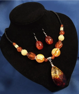 Detail eines Bernstein-Harz-Schmucksets mit Perlenkette und Tropfenanhänger auf Büste