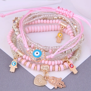 Détail de bracelets en perles roses avec breloque cœur Love et pendentifs main de Fatima