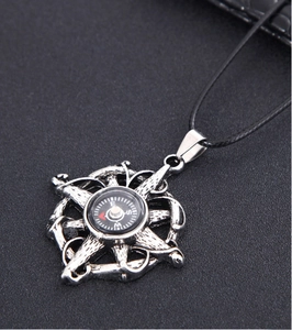 Macro shot of vintage silver compass pendant with starburst frame and black cord