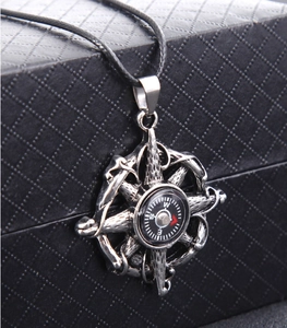 Close-up of vintage compass pendant with helm design on a black textured jewelry box