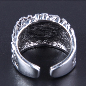 Macro shot of silver vintage embossed ring with textured detail and open adjustable band