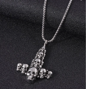 Close-up of gothic skull inverted cross pendant on a square box chain with vintage finish