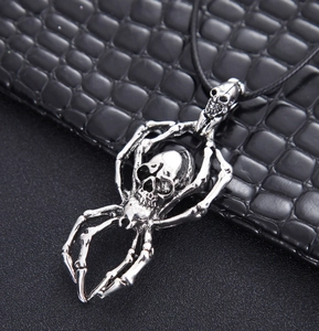 Détail d'un pendentif araignée crâne en argent rétro de style gothique punk sur cordon