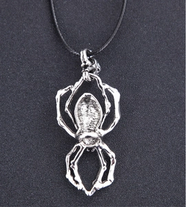 Détail d'un collier pendentif araignée argentée vintage aux textures punk complexes