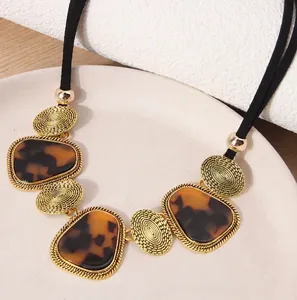 Collier doré imposant avec pendentif en résine écaille de tortue et cordon noir élégant