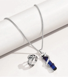 Detailed view of dragon wrap necklace with blue crystal and vintage skull ring set