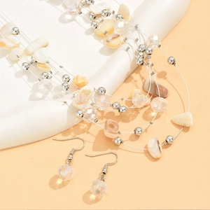 Detailed shot of multilayer necklace and earrings with shell fragments and crystal beads