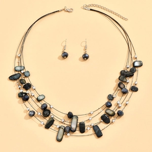 Detail of layered necklace with crystal beads, gray shell pieces and matching earrings