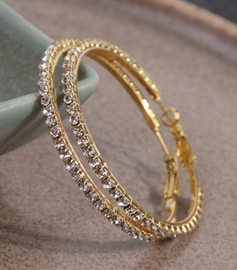 Detail of 5.0cm gold-plated hoop earrings with sparkling rhinestones on ceramic base