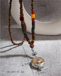 Vue détaillée du long collier ethnique en bois avec pendentif en métal gravé