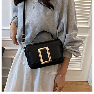 Chic black handbag with gold buckle shown on a model for daily crossbody styling
