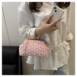 Detail of pink floral evening bag with faux pearls and golden lace clasp handle