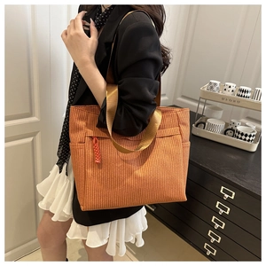 Detail of orange woven tote bag showing texture and stylish nylon strap handles