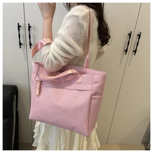 Detail of pink woven texture on large tote bag with side pocket and shoulder strap