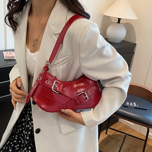 Chic red patent leather underarm bag with silver buckles and Y2K punk grommet details