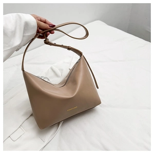 Détail du sac fourre-tout minimaliste en cuir marron clair avec logo doré FASHION & BAGS et fermeture