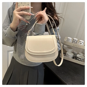 Detail view of cream crossbody bag with adjustable strap and fine stitching finish