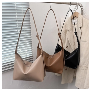 Détail de sacs fourre-tout demi-lune minimalistes en similicuir mat rose, marron et noir