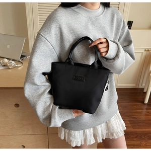 Detailansicht der modischen wasserdichten schwarzen Nylon-Handtasche im Home-Office-Stil