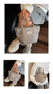 Nahaufnahme der grauen wasserdichten Nylon-Handtasche mit Fashion-Label auf Holztreppe