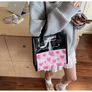 Dettaglio della borsa in PVC trasparente con cuori e testo Leave love and take away regret