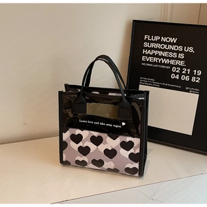 Dettaglio della borsa nera con motivo a cuori e pannello in PVC con slogan di testo