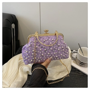 Close-up of a purple floral clutch with delicate white pearls and a gold chain strap