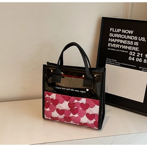 Dettaglio della borsa tote in PVC con testo bianco cuori e manici in tela neri