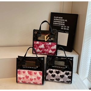 Tre borse in tela con stampa a cuore in rosa e grigio con dettagli in PVC nero e manici