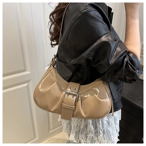 Détail du sac baguette en cuir verni kaki avec large boucle et finitions métalliques