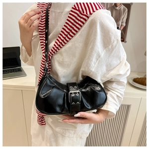 Détail du sac croissant noir plissé avec bandoulière à boucle et œillets métalliques