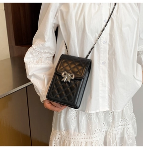 Dettaglio della mini borsa porta cellulare nera trapuntata con fiocco d'argento