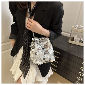 Silver sequin bucket bag with chain strap styled on a model with a black blazer